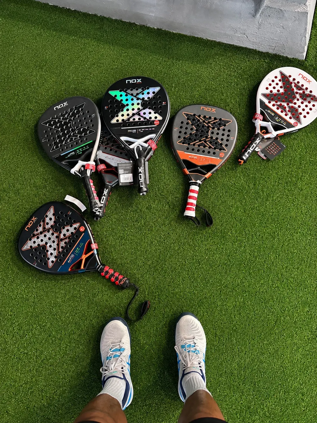 Padel rackets and balls laid out on artificial grass